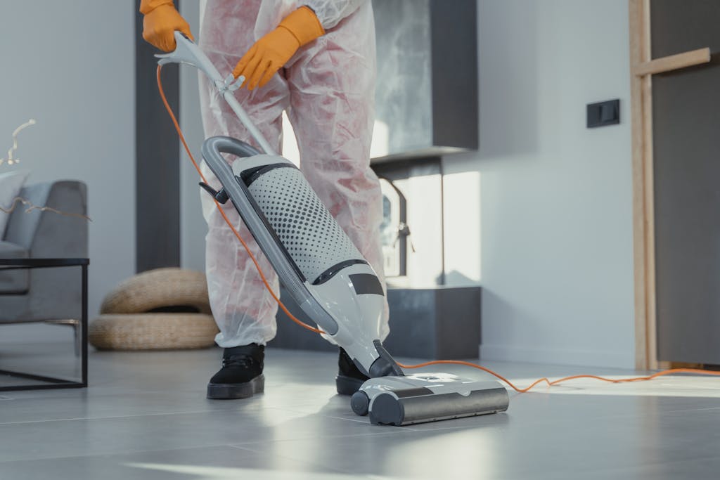 Person Using a Vacuum on Floor Tiles