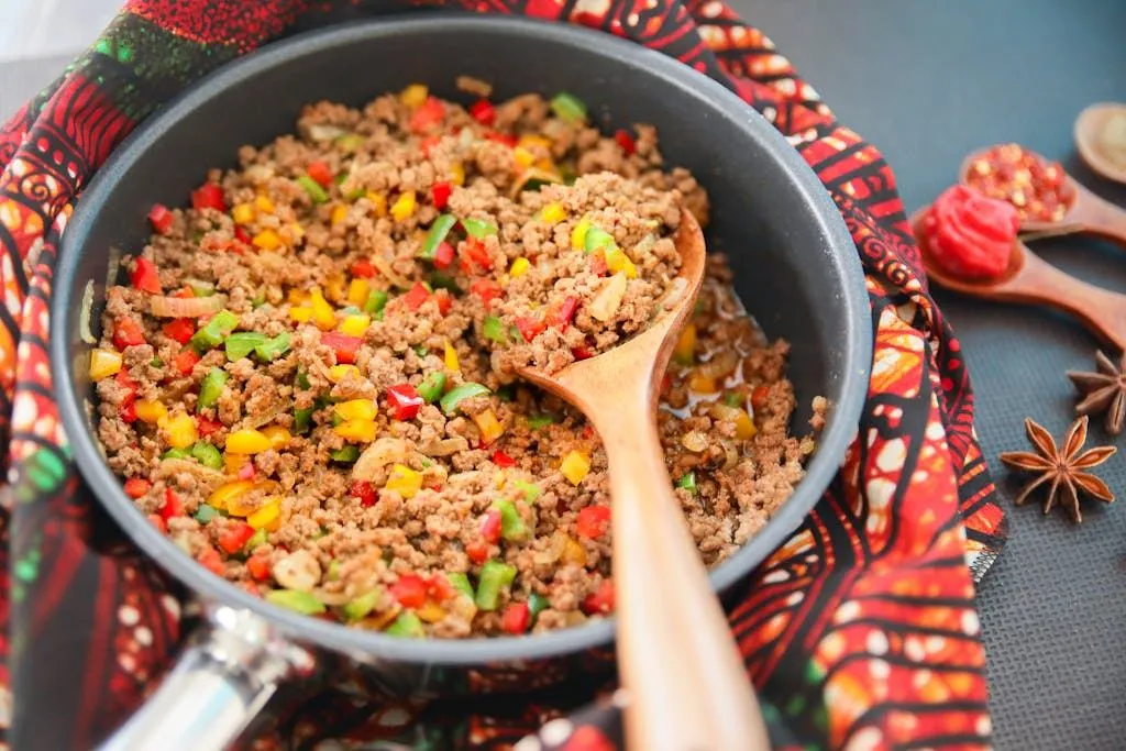 Vibrant picadillo cooked with red, green, and yellow bell peppers in a pan.